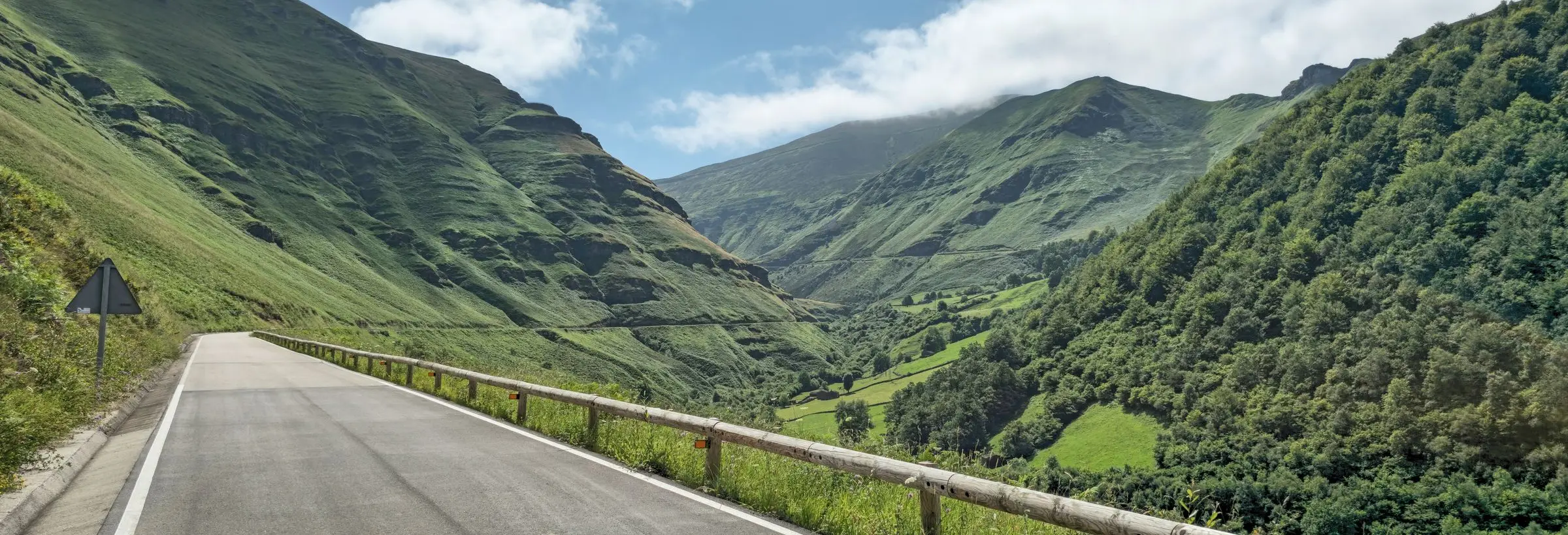 Carretera CA-631 entre los prados de Vega de Pas, con el valle al fondo